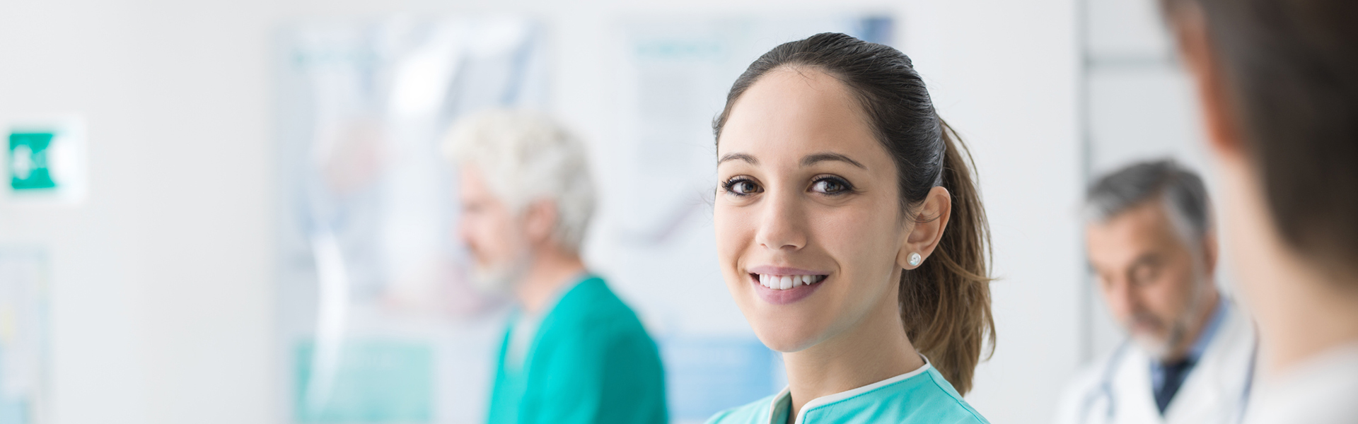 MFA schaut in Kamera, im Hintergrund sind Kollegen zu sehen