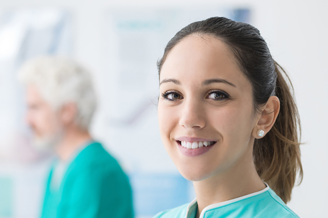 MFA schaut in Kamera, im Hintergrund sind Kollegen zu sehen