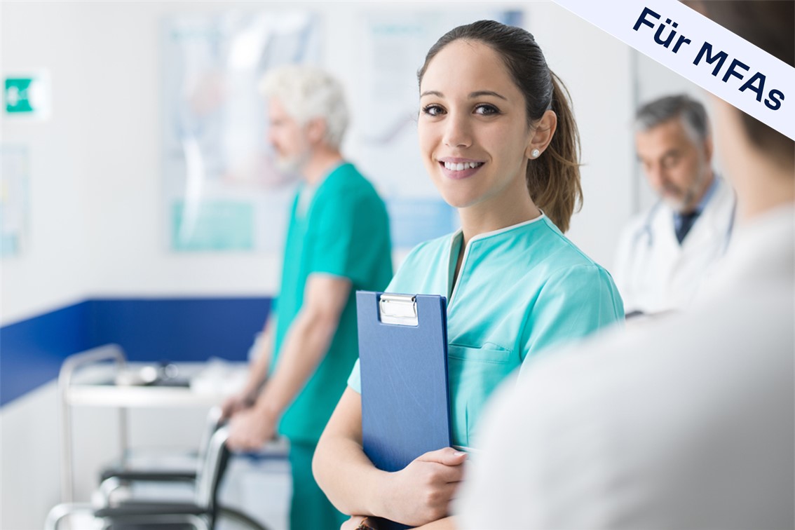 MFA schaut in Kamera, im Hintergrund sind Kollegen zu sehen