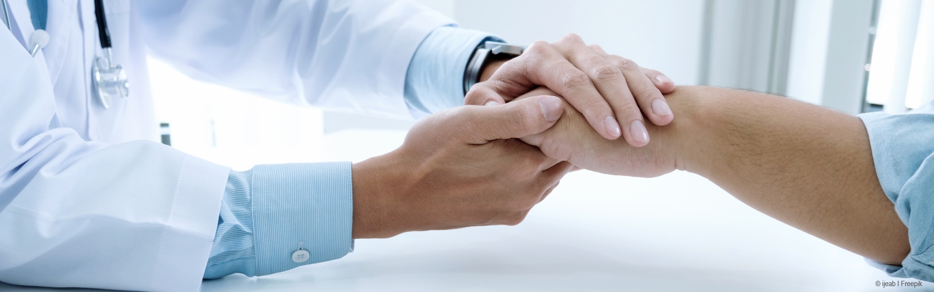 Nahaufnahme von Händen eines Arztes, die eine andere Hand halten