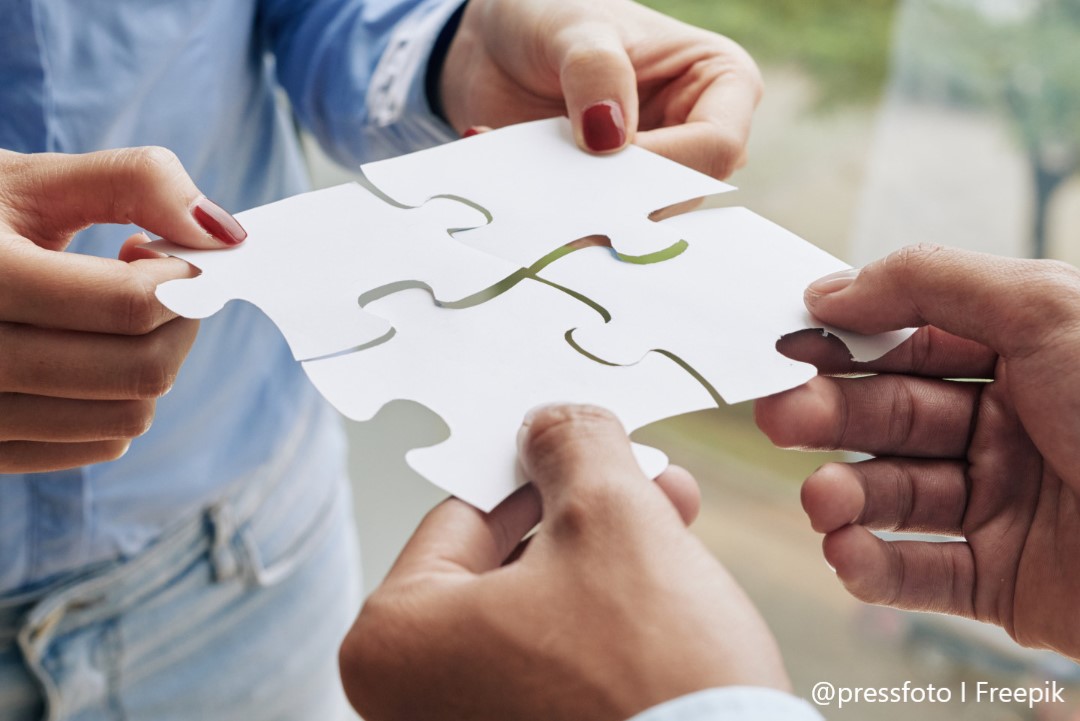 Symbolbild: Zwei Personen fügen Puzzle-Teile zusammen.