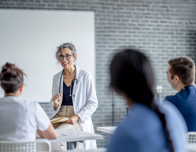 Medico sorridente di fronte ad alcuni studenti