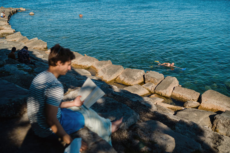Uomo che legge in riva al mare