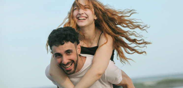 Giovane coppia sorridente sulla spiaggia