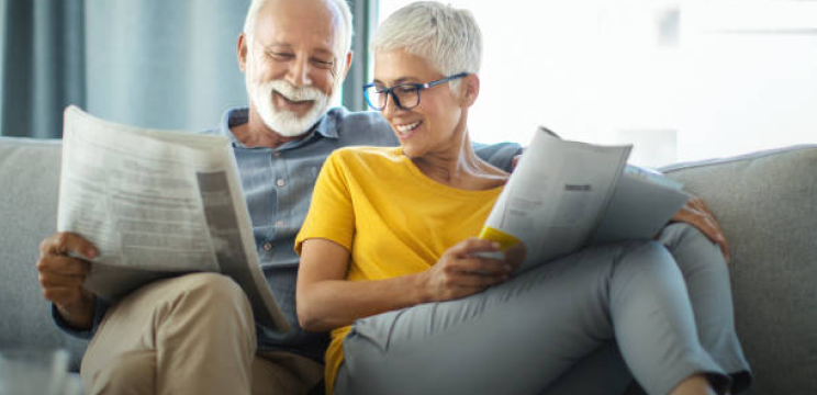 Serena coppia di mezza età legge il giornale sul divano