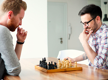 Due giovani impegnati in una partita di scacchi