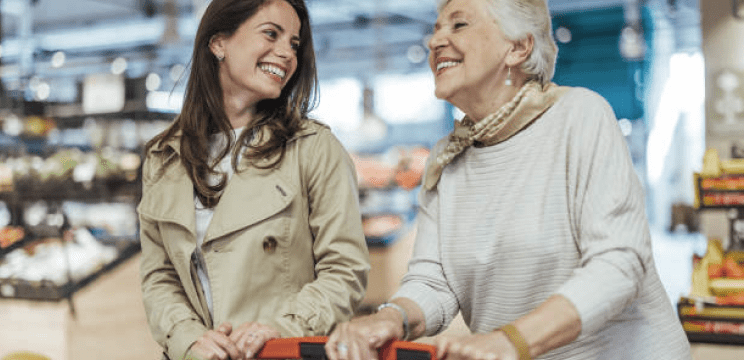 Donna fa la spesa mentre scambia sorrisi con la madre