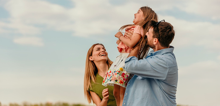 Famiglia felice gioca all'aperto con la figlia