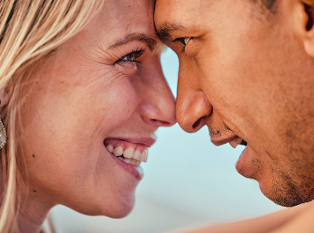 Coppia sorridente con le fronti unite, sguardi affettuosi