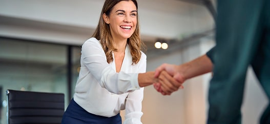 Donna in carriera sorride mentre stringe un accordo