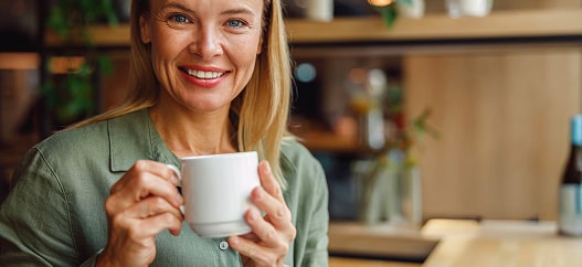 Donna sorridente con in mano una tazza di tè 