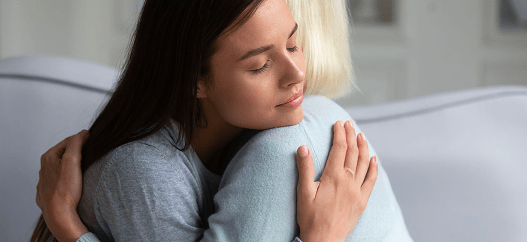 Due donne si abbracciano con affetto sul divano