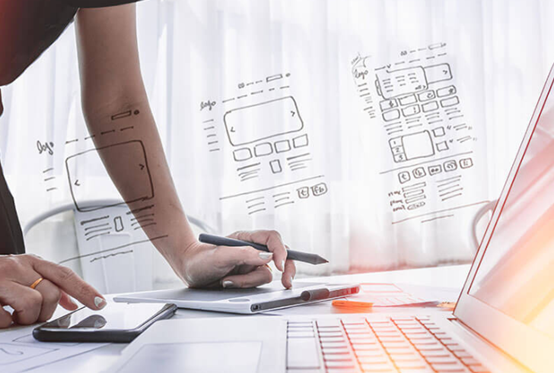 Person står vid vitt bord och skriver på mobiltelefon