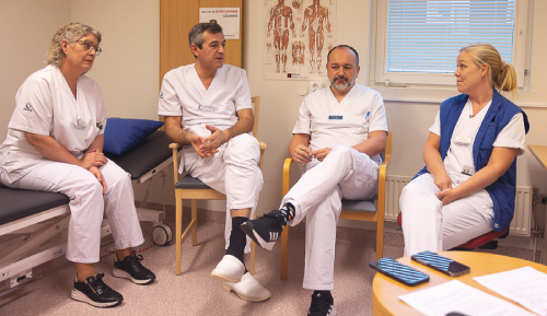 fyra sjukvårdare sitter i ett rum på spasticitetsmottagning